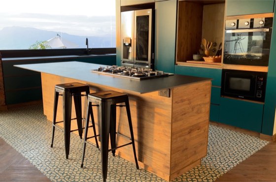 Cocina con isla de madera y ventanal hacia las montañas