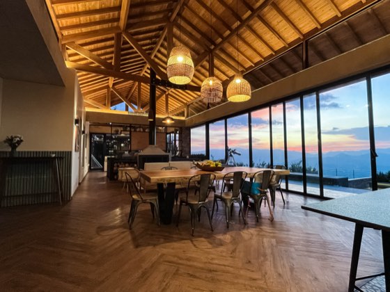 Comedor al atardecer con techo de madera y vista panorámica