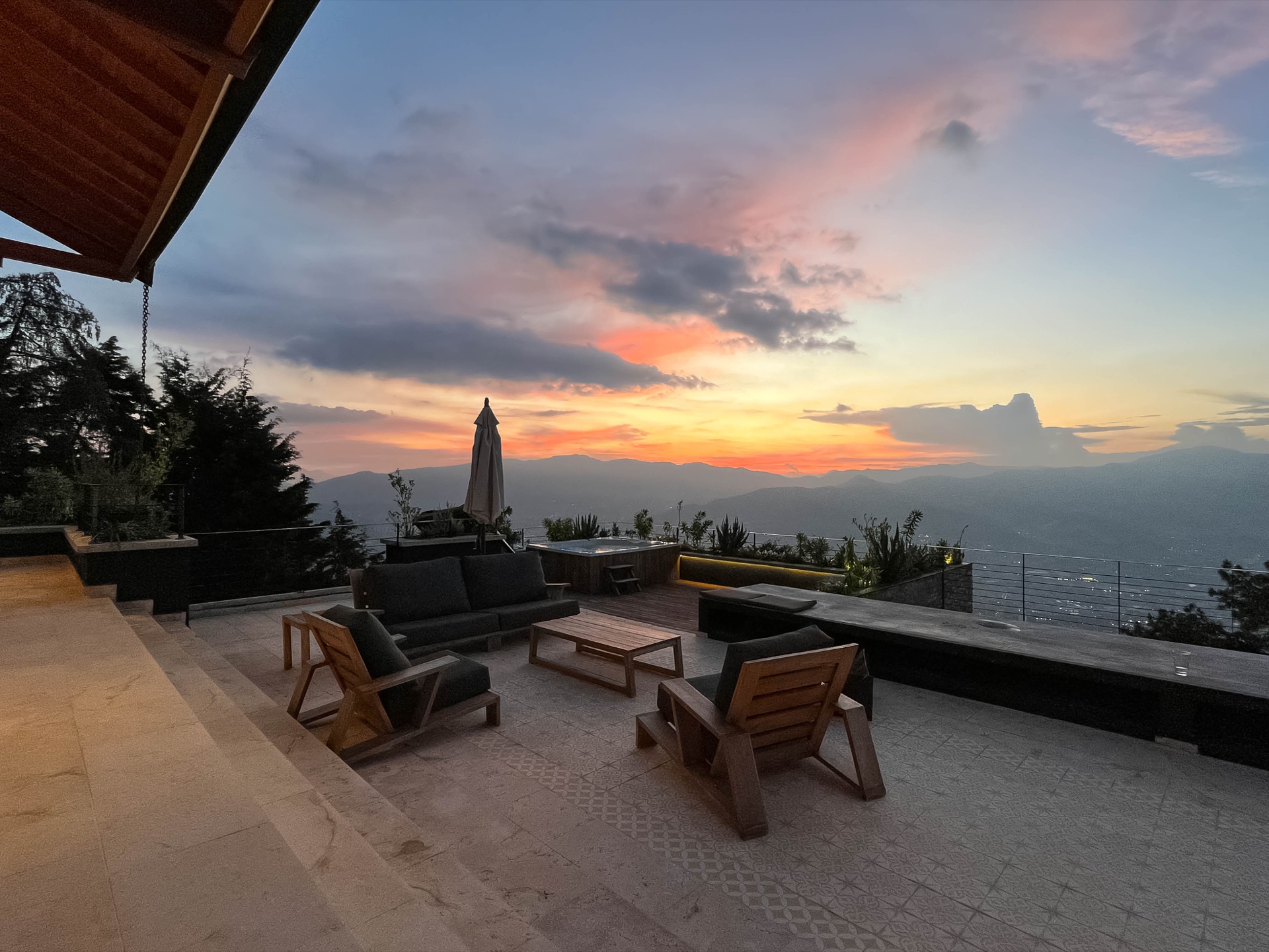 Terraza con jacuzzi y vista al atardecer sobre Medellín en Villa Esmeralda, Las Palmas