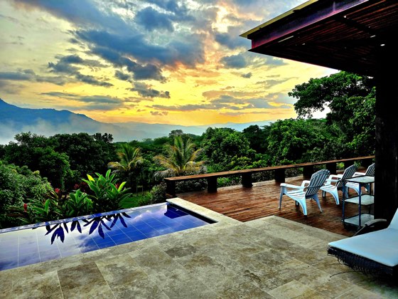 Piscina al amanecer con mar de nubes en el valle