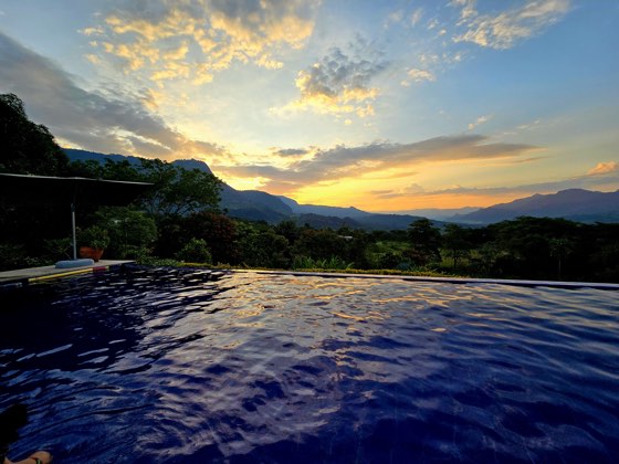Piscina infinita con reflejos dorados y cielo espectacular
