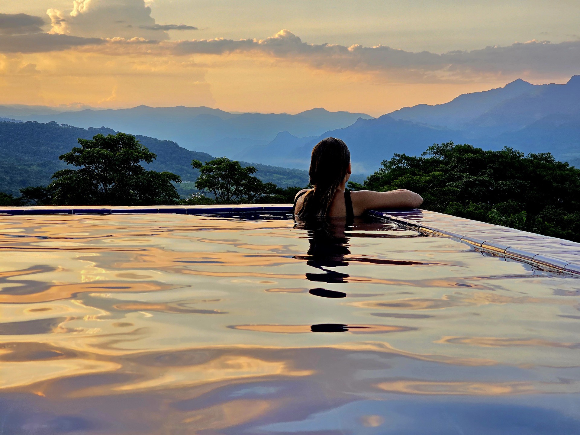 Piscina infinita de Villa Las Guacamayas al atardecer frente a las montañas del Suroeste antioqueño