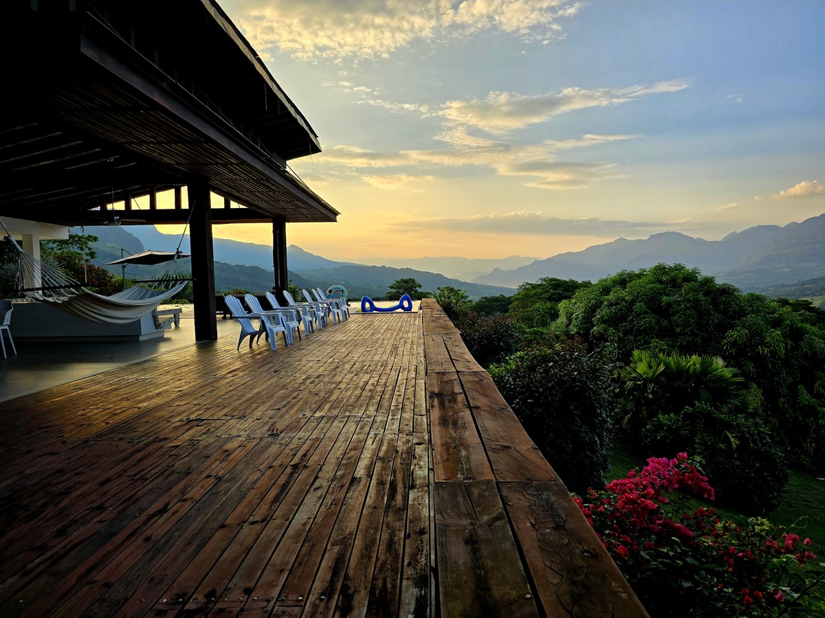 Terraza de madera con hamacas al atardecer en Villa Las Guacamayas
